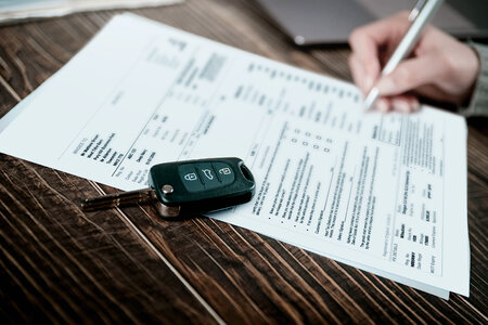Man signing car insurance document or lease paper photo