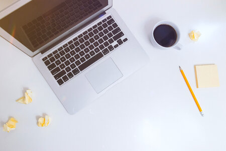 White desk with notes, coffee and laptop photo