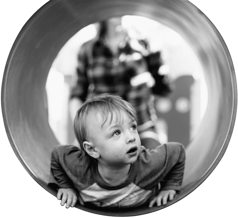Grayscale photo of child in hole