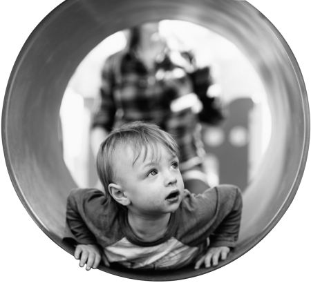Grayscale photo of child in hole