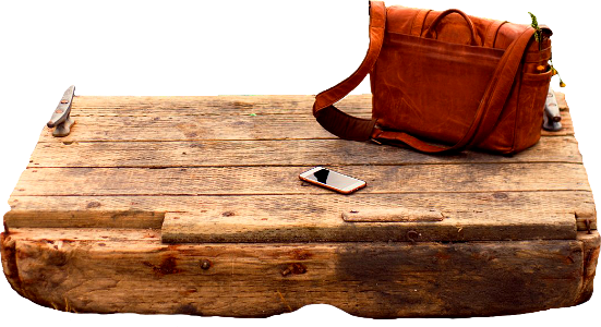 Brown leather crossbody bag on brown wooden panel near water