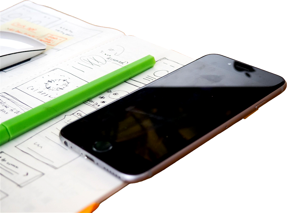 Phone and sketchbook on wooden desk