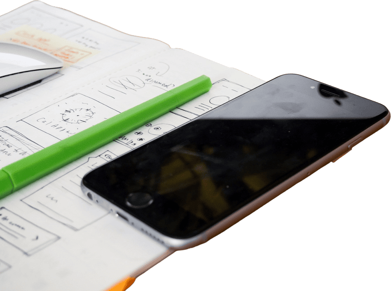 Phone and sketchbook on wooden desk