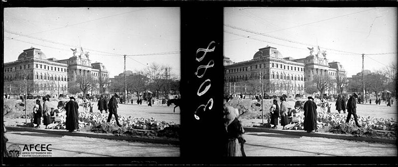 Plaza de Madrid under construction with several people in the foreground and the Palacio de Fomento in the background, 1922
