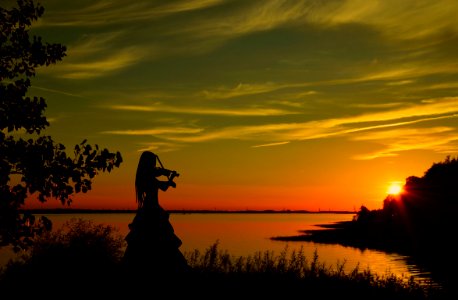 Silhouette of Woman Playing Violin at Sunset. Free illustration for personal and commercial use.