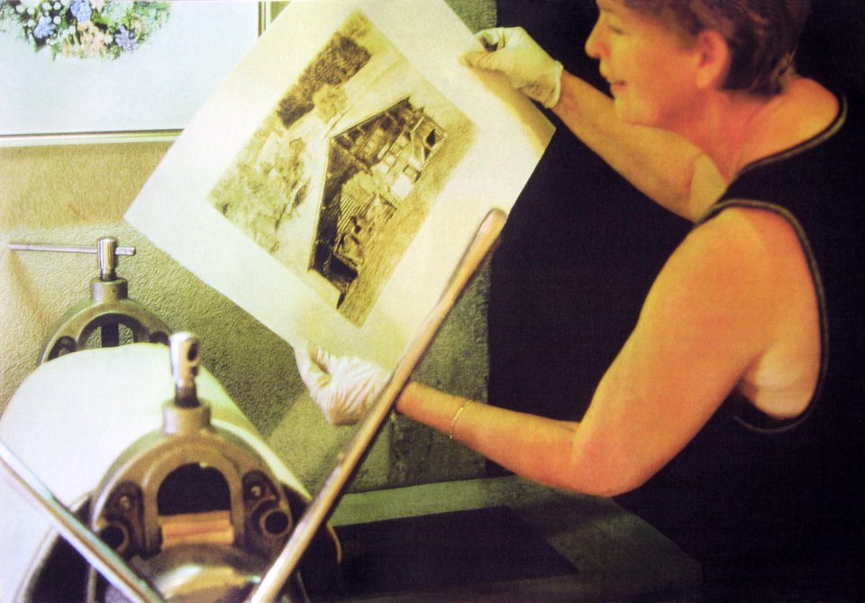 Hubertine lifts an etching of a farmhouse in Feutersoey of…