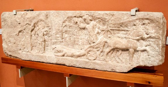 Achilles dragging Hectors's body, in the backgrounde the walls of Troy