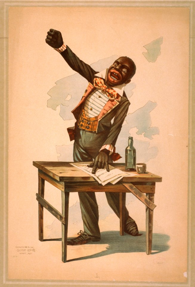 African American, standing at desk, with one hand resting on papers and one hand raised LCCN2014637038