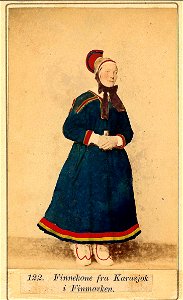 122. Konedrakt, samedrakt, Karasjok. Portrett av kvinne i hornlue stående ant - Norsk folkemuseum - NF.11770-007 (1)