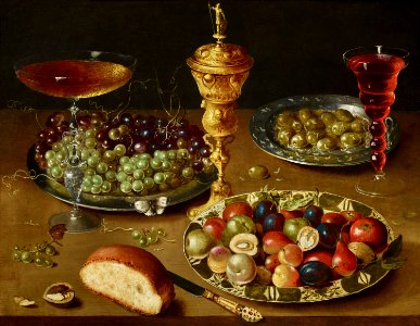 Osias Beert (I) - Still life with a hanap, dish of grapes, bowl of fruit, olives, bread and glass of wine. Free illustration for personal and commercial use.