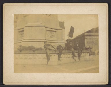 Dam. Rustende mannen op de sokkel van het 'Monument ter herinnering aan den volksgeest van 1830-1831', bekroond door het beeld van De Eendracht ('Naatje van de Dam'), Afb ANWZ00380000001