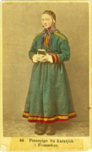 64. Jentedrakt, kvinnedrakt, samedrakt, Karasjok. Portrett av pike stående ant - Norsk folkemuseum - NF.08676-001 (1)