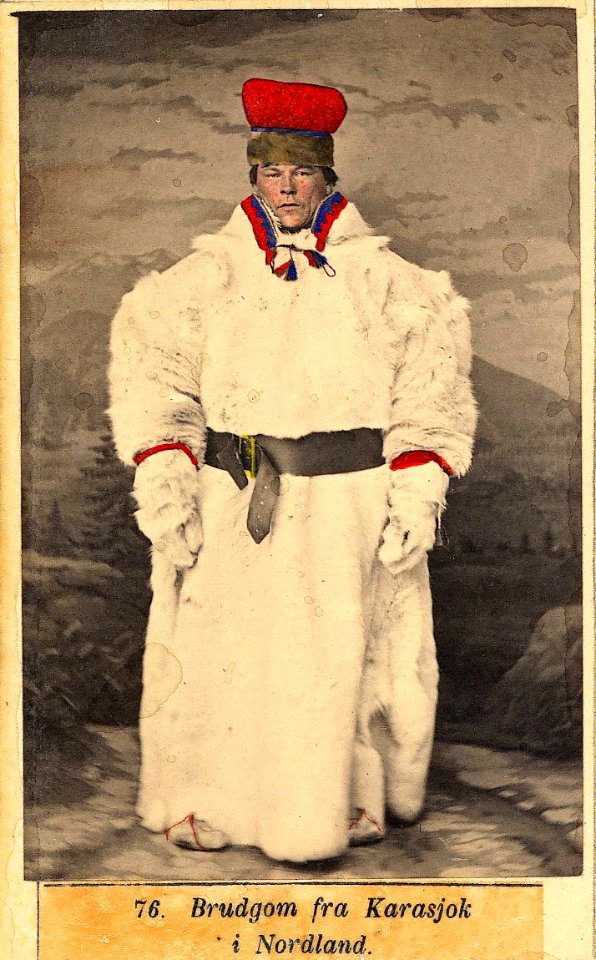 76. Brudgomsdrakt, samedrakt, fra Karasjok. Portrett av mann stående i skinnklær, ant - Norsk folkemuseum - NF.09398-019 (1)