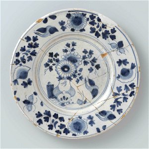 Bord met op het plat een vaas met bloemen en een vogel in blauw