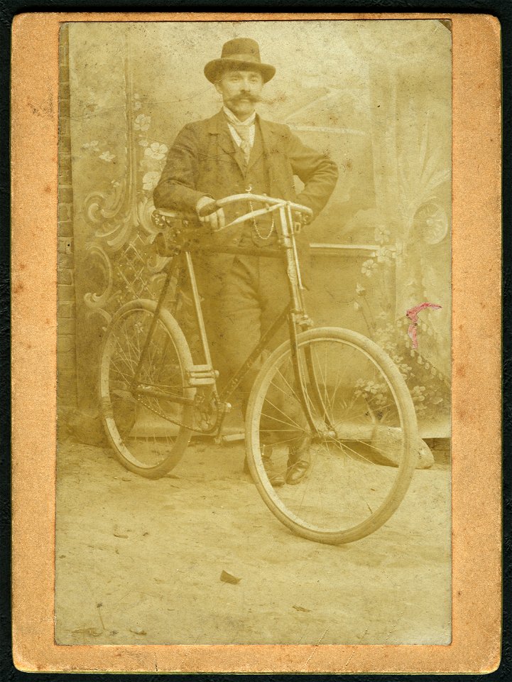 Der Maler Wilhelm Mohrbotter mit Fahrrad im Hof in Celle vor gemaltem Hintergrund, Aufnahme mit „Selbstauslöser“