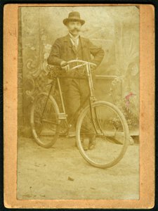 Der Maler Wilhelm Mohrbotter mit Fahrrad im Hof in Celle vor gemaltem Hintergrund, Aufnahme mit „Selbstauslöser“