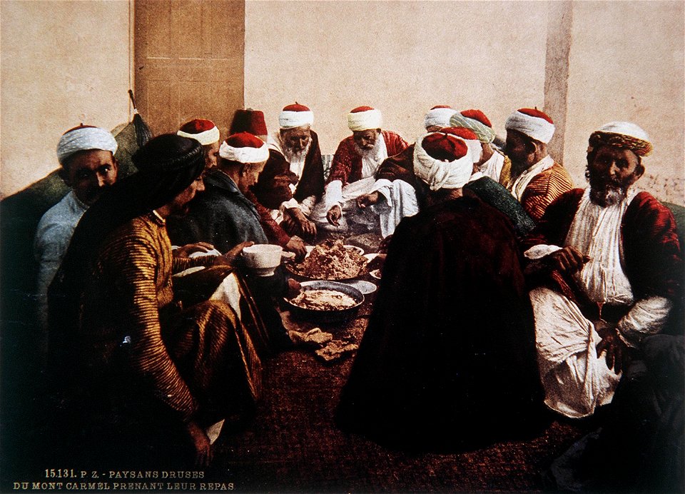 DRUSE RESIDENTS OF THE CARMEL FEAST ON A MEAL OF TRADITIONAL FOODS. COLOR PHOTO TAKEN IN THE LATE 19TH CENTURY BY FRENCH PHOTOGRAPHER, BONFILS. צילום צבע מסוף המאה ה19 של הצלם