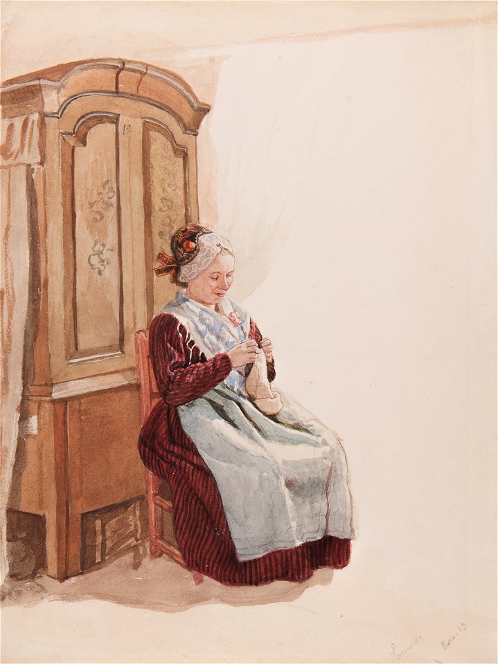 Dräkt. Handarbetande kvinna i helfigur sittande framför ett skåp - Nordiska museet - NMA.0070148 (1)