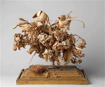 Bloemenruiker van geknipt papier met vogelnestje, onder stolp.