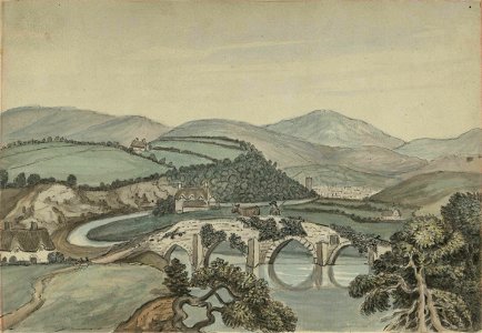 Four-arched stone bridge over river, looking towards a town, hills in the background (1205512)