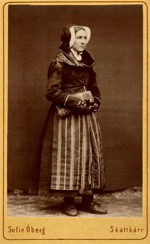 Kvinna står klädd i folkdräkt - Nordiska Museet - NMA.0042866