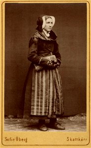 Kvinna står klädd i folkdräkt - Nordiska Museet - NMA.0042866