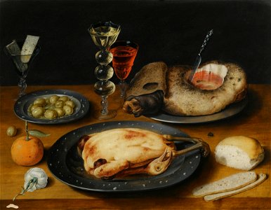 Still Life of a Roast Chicken, a Ham and Olives on Pewter Plates with a Bread Roll, an Orange, Wineglasses and a Rose on a Wooden Table. Free illustration for personal and commercial use.