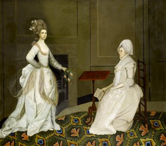 Two ladies in an interior one reading the other holding a garland of flowers