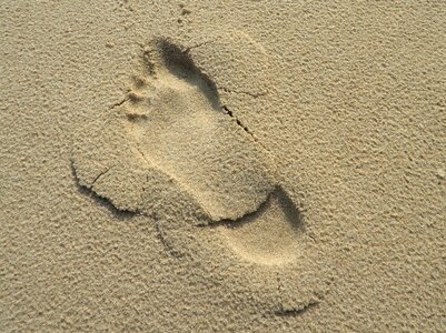 Human foot tracks in the sand photo