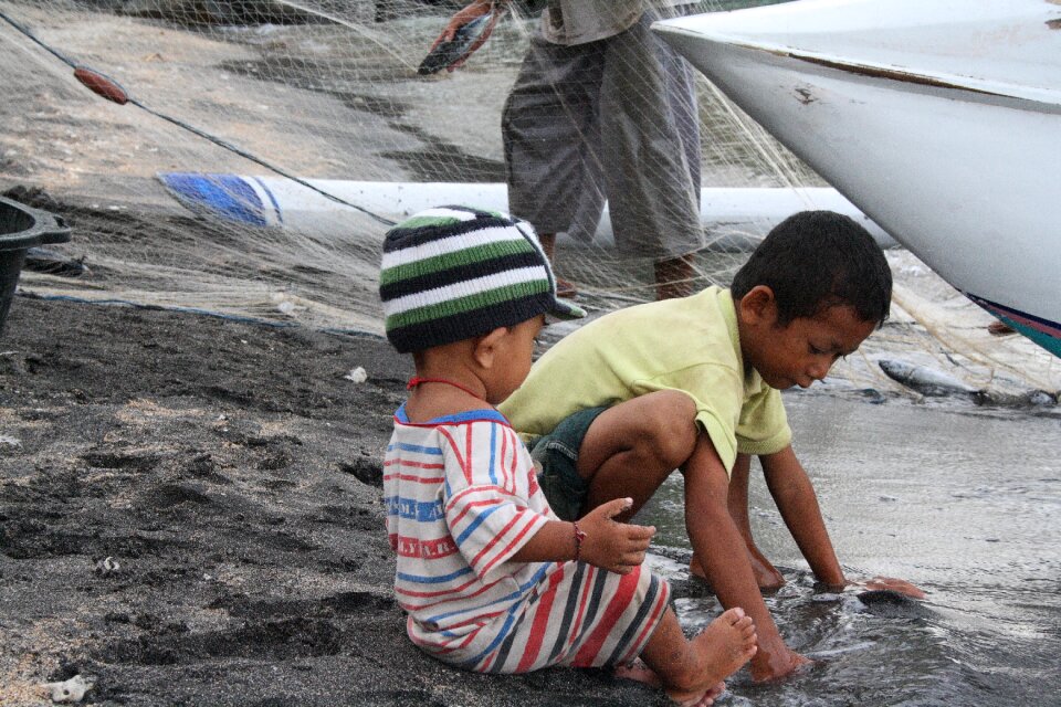 Beach children fishing boats