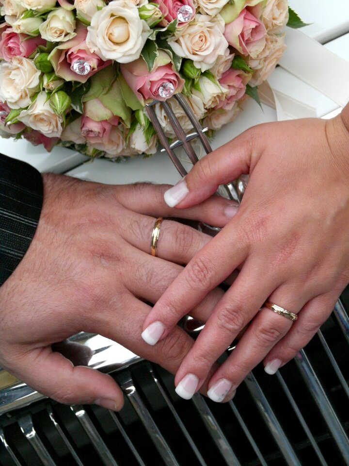 Wedding bride and groom hand with wedding bands spouses