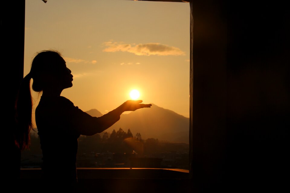 Sunset woman holding the sun