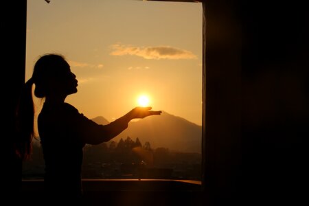 Sunset woman holding the sun