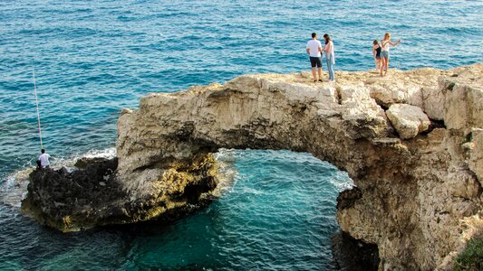 Tourists sightseeing natural arch photo