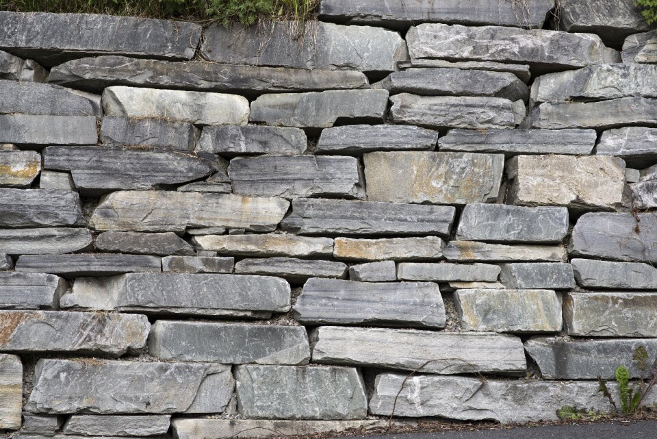 Hewn stone wall carved grass