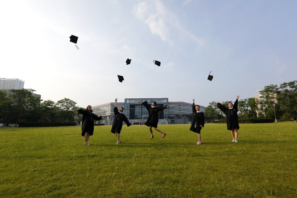 Classmate jump throwing hats