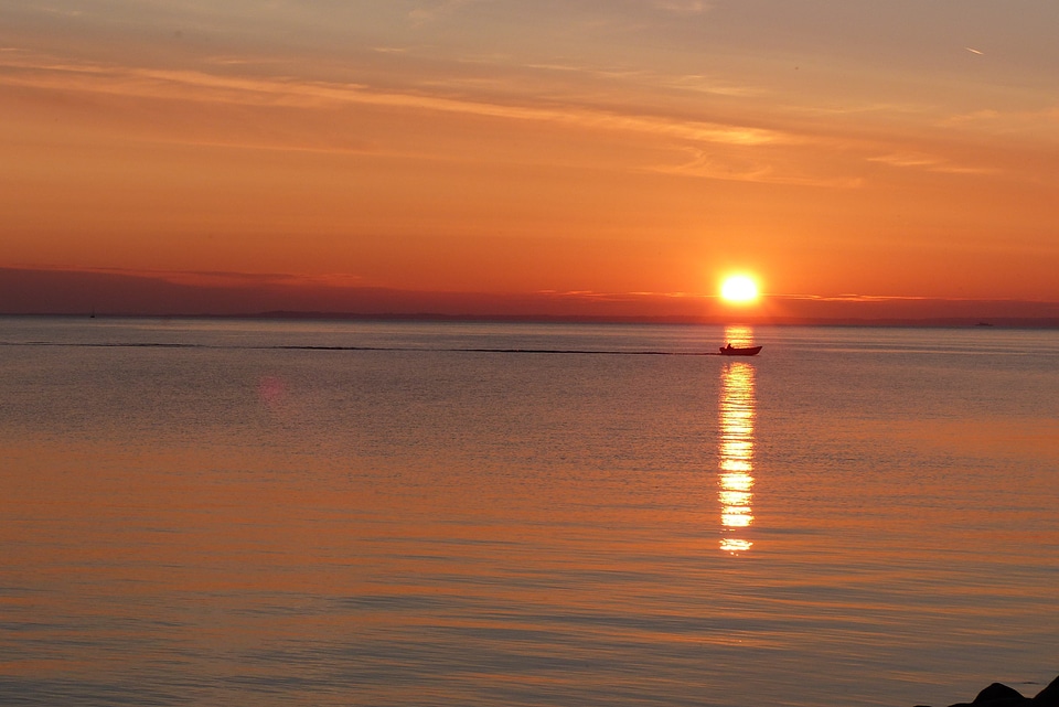 Boat mirroring sun