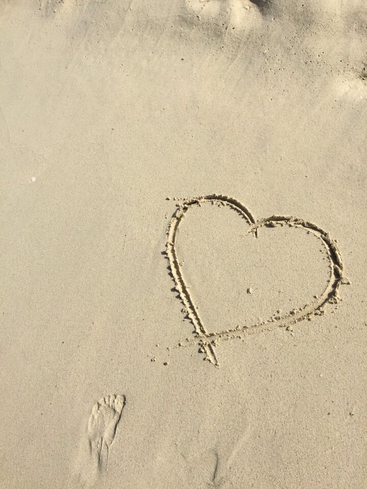 Beach drawing the shape of heart
