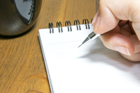 Hand and pen writing white laptop