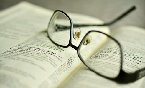 Holy scripture book pages reading glasses photo