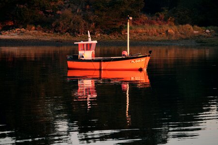 Sunrise boat reflection on the water photo