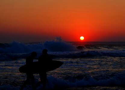 Men surf sea