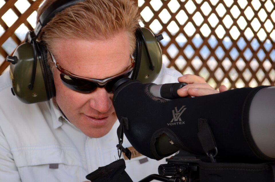 Man looking through spotting scope long range rifle spotter