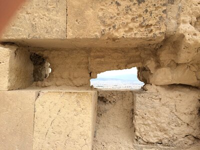 Hole in the wall peeping stone wall photo