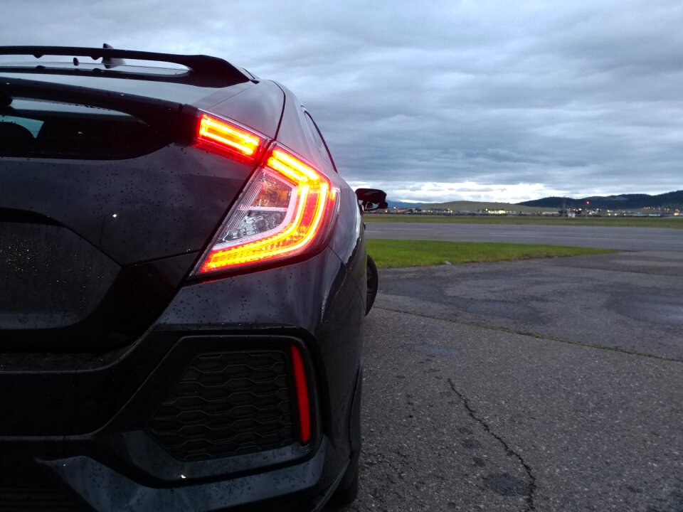 Car tail lights dark sky
