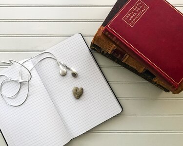 Stacked books ear buds heart-shaped photo