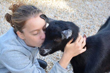 Young woman goat tenderness