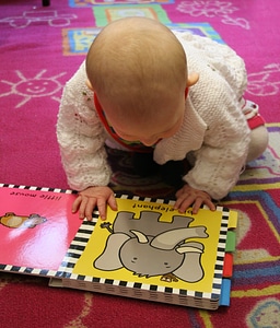 Toddler reading baby photo