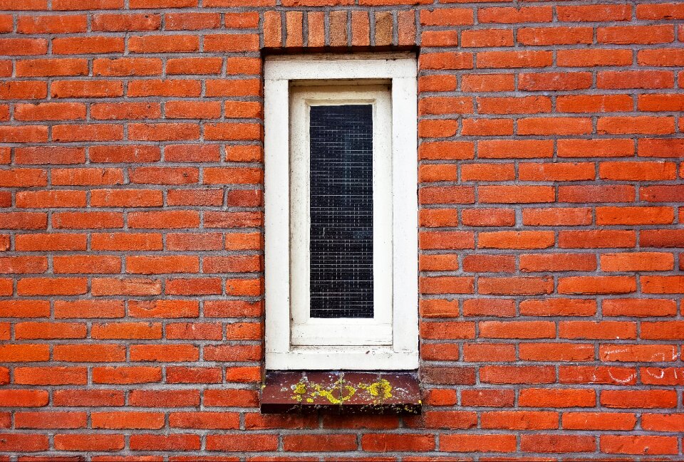 Narrow window white window brick wall photo