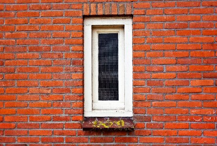 Narrow window white window brick wall photo